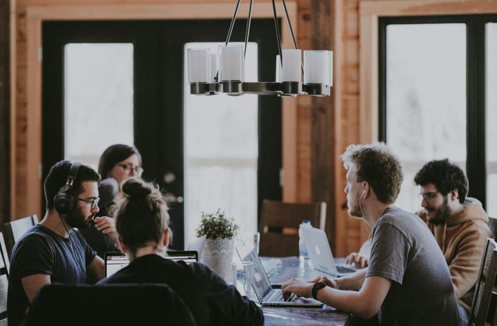 Kleines Geschäftsteam bei der gemeinsamen Prüfung eines digitalen Arbeitsablaufs